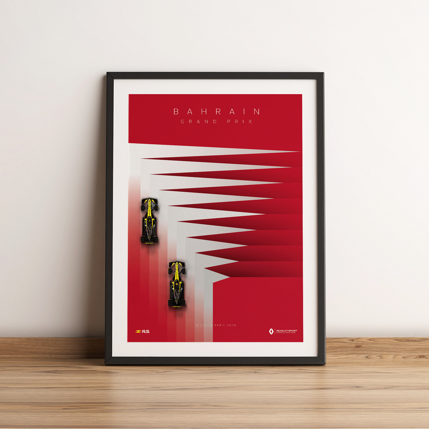 a framed poster of a race car on a wooden table